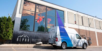 A woman leans against a storefront with large, bold window graphic film
