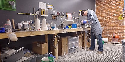 Worker at a bench forming a prosthetic limb
