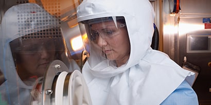 pharmaceutical manufacturing worker wearing respirator hood
