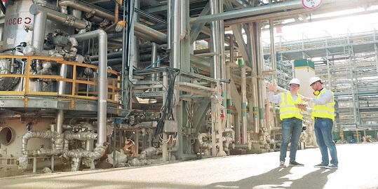 two workers in safety gear at an industrial facility